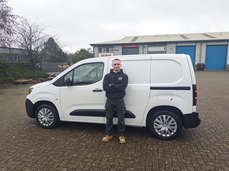Tyler Baker of TB Electrical standing beside the company van