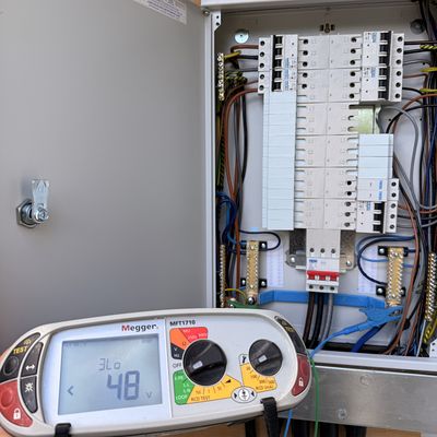 Megger multifunction tester in use on an open distribution board