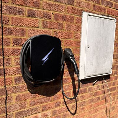 Wall-mounted home EV charge point installed on a brick wall